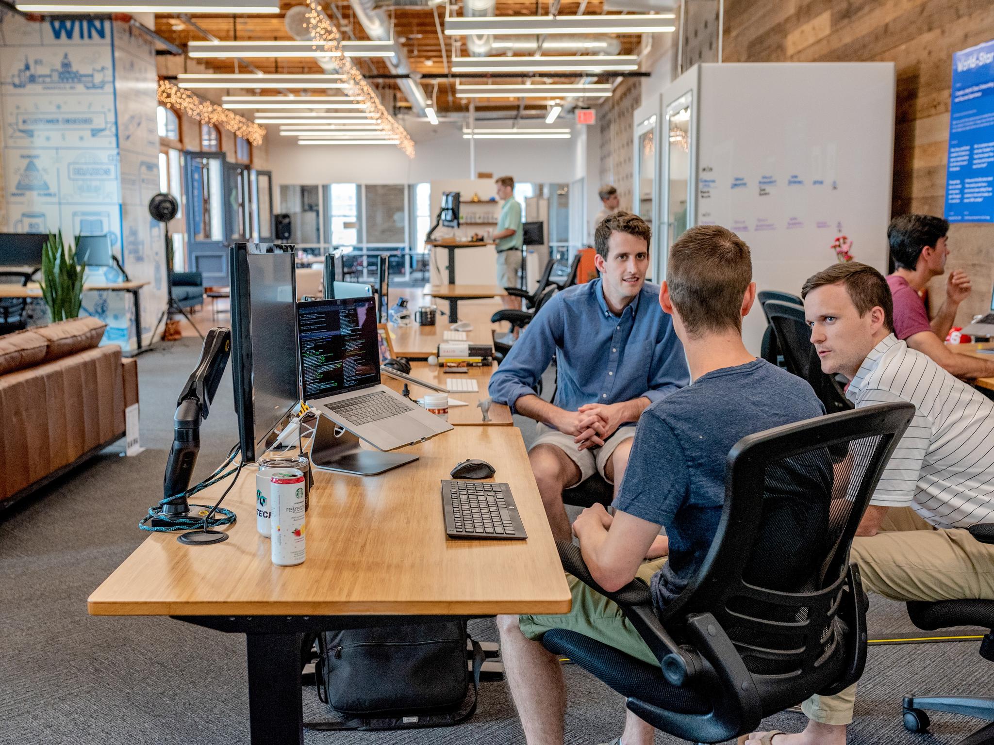 Group of Colleagues Engaged in a Work Discussion in an Open Office